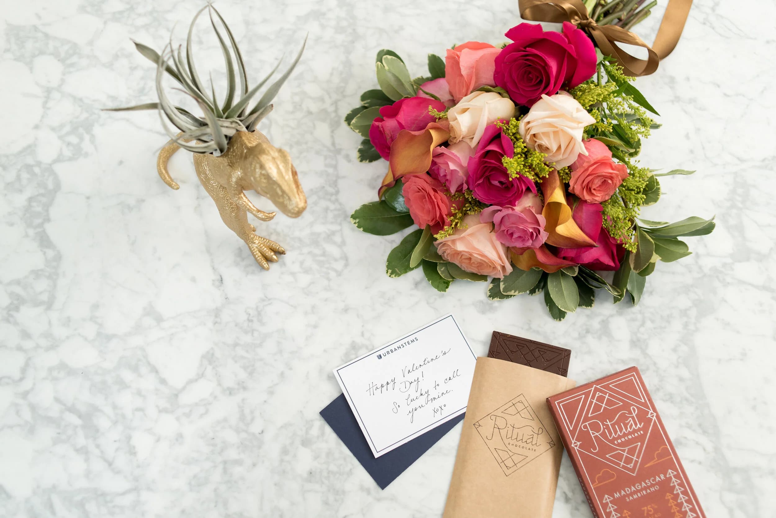 Valentine's Day flat lay — flowers, card, and chocolate