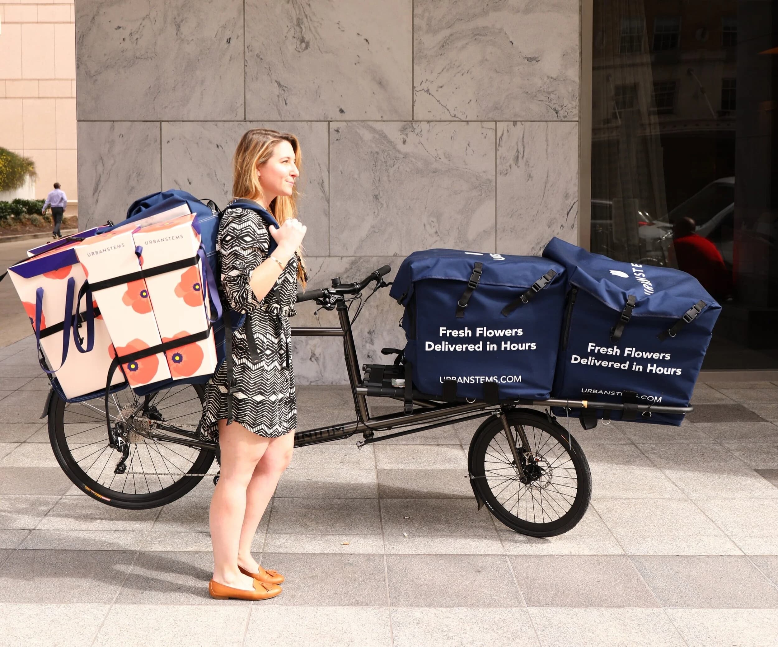 Liz testing the UrbanStems backpack system alongside the branded cargo bike