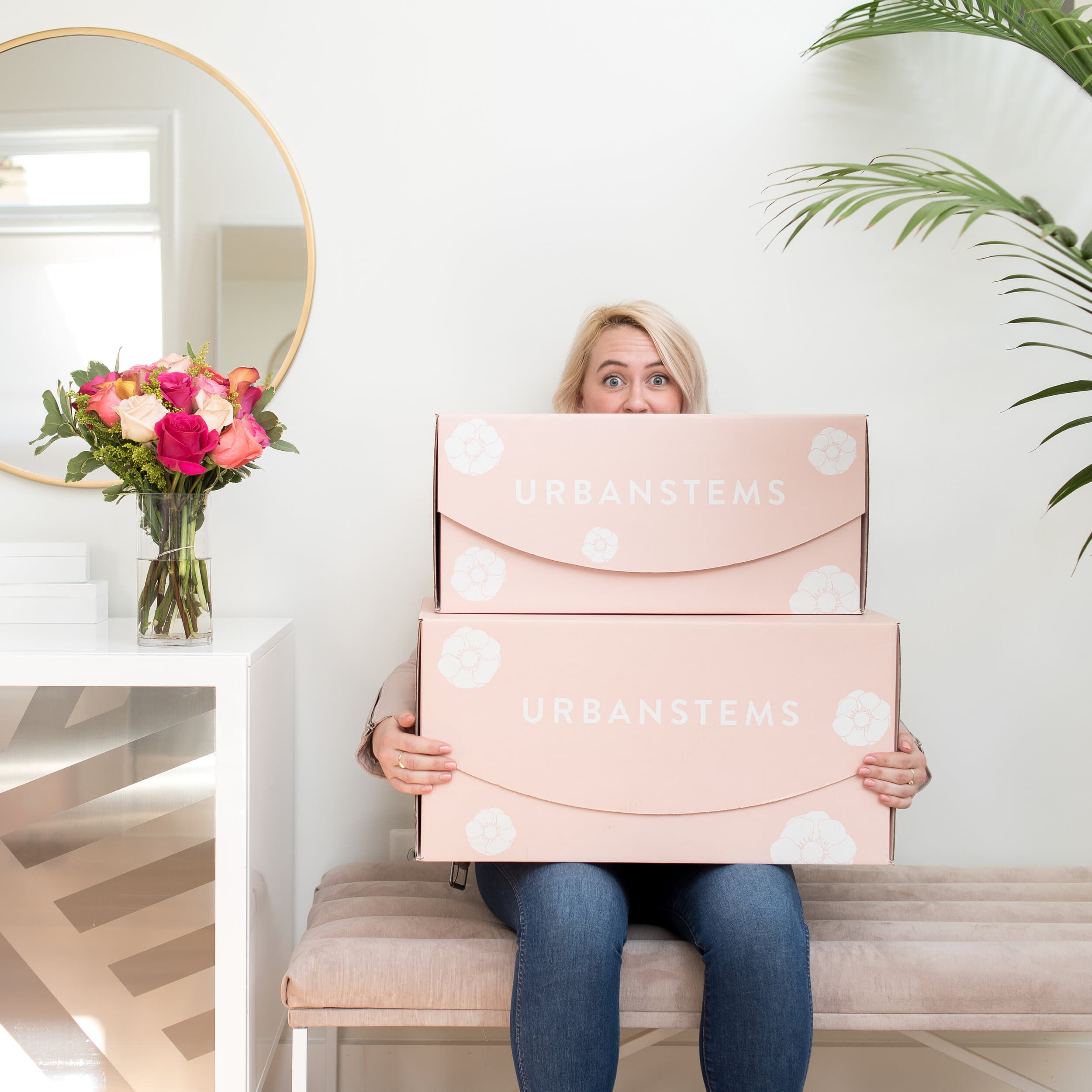 Customer holding two blush UrbanStems FedEx boxes