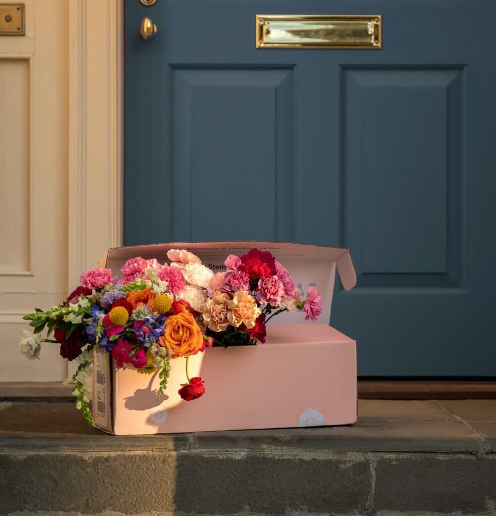 UrbanStems FedEx box on a doorstep — flowers blooming out of the open lid